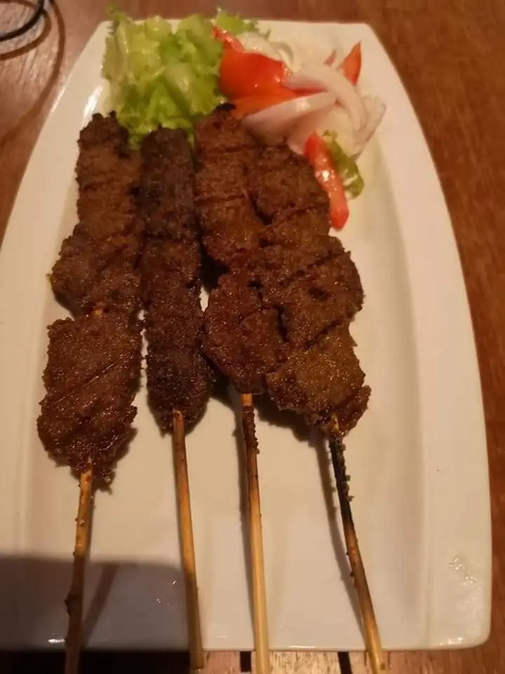 Des brochettes de viande grillée sur une assiette.