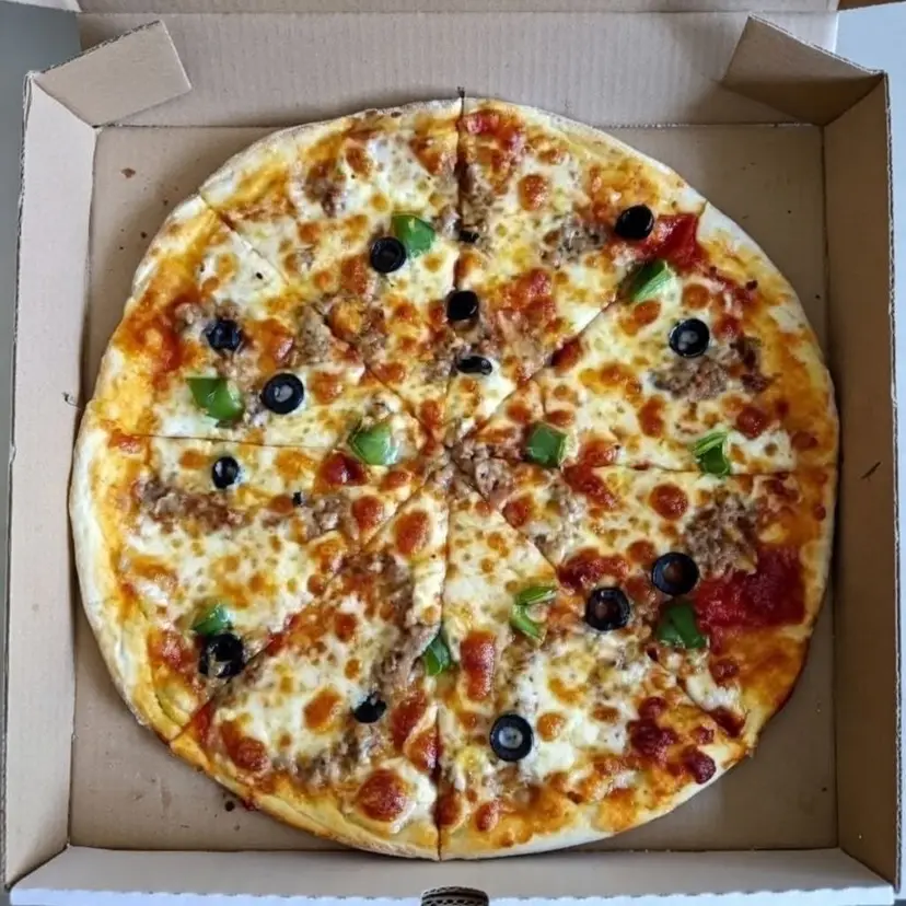 Une pizza garnie d’olives et de tomates, dans sa boîte.
