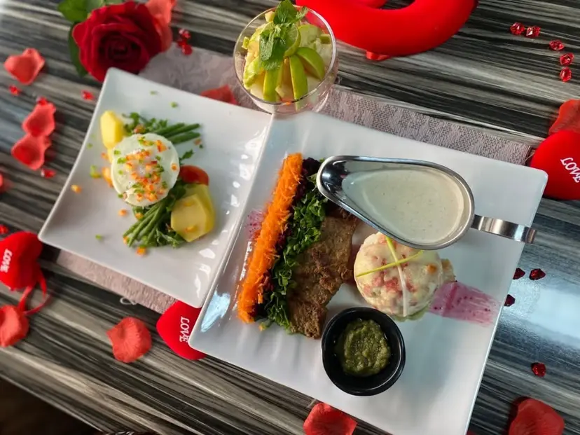 Une assiette dressée : viande, purée, carottes et sauce.